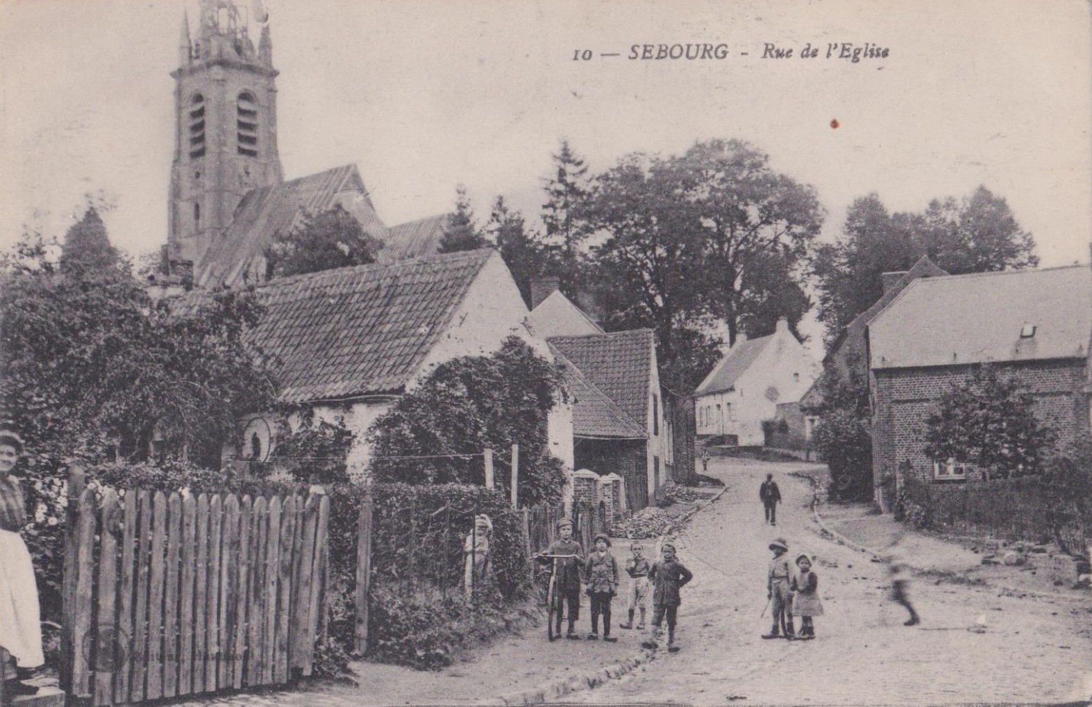 La rue de l'église à Sebourg sur une carte postale ancienne